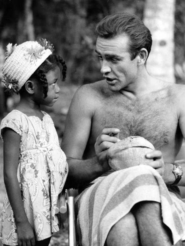 Sean Connery signe une noix de coco pour une petite admiratrice jamaïcaine sur le plateau de Dr No. [1962]
