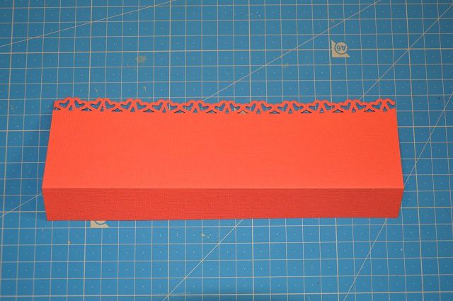 Dans le papier rose saumon, découper une bande de 8.5 cm sur 21cm. Plier en deux à 2cm du bord et perforer toute la hauteur de l'autre côté.
