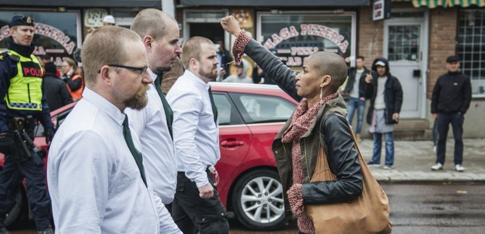 Cette photo a été prise par le photographe David Lagerlof le 1er mai 2016 à Borlange, en Suède, lors d'une manifestation anti-immigration organisée par un groupe néonazi, le Mouvement de Résistance Nordique. On y voit Tess Asplund, une militante antiraciste, devant trois leaders du groupe, brandissant pacifiquement et silencieusement le poing en signe d'opposition.