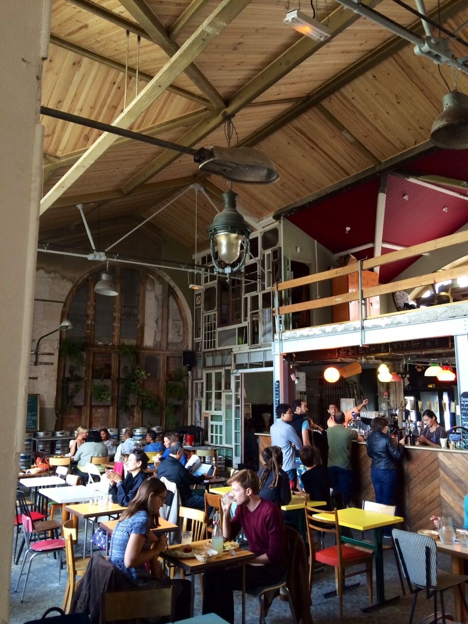 La grande salle avec son volume magique (un tel espace est exceptionnel à Paris), brute de décoffrage, avec ses meubles chinés Emmaus