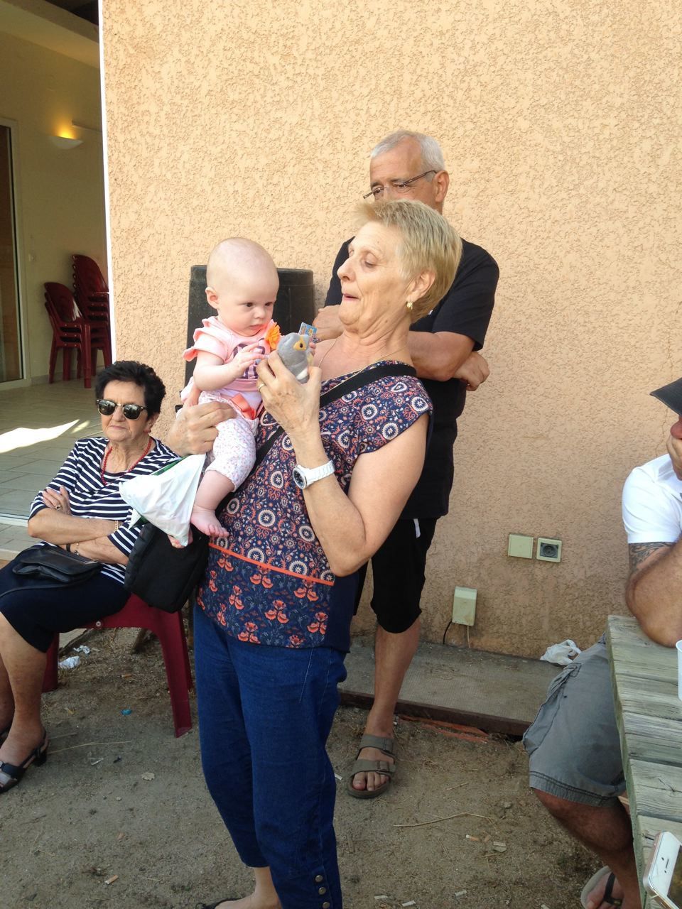 Ghjulia Laura dans les bras de ses grands-parents.