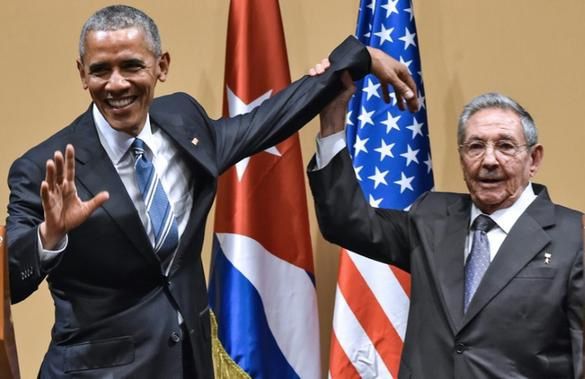 Le président cubain Raul Castro lève la main du président américain Barack Obama © Nicholas Kamm
