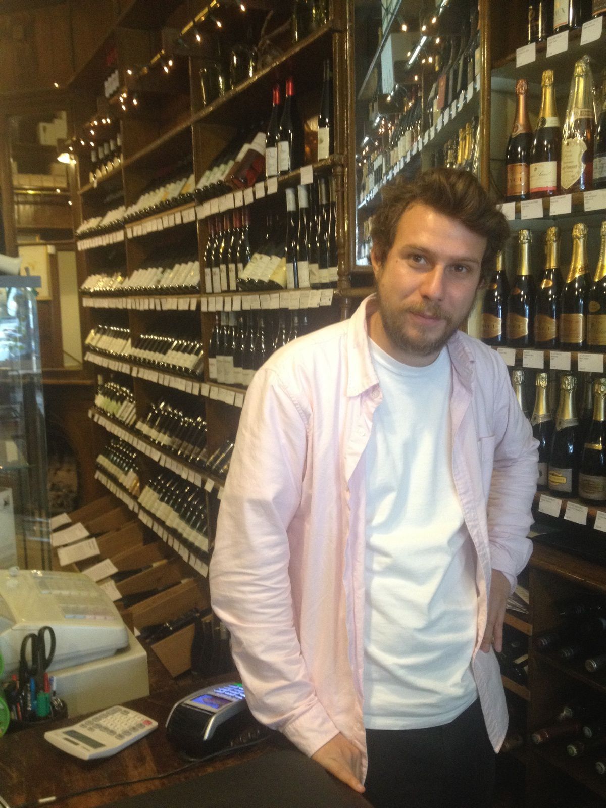 A french with a pink shirt in a old wine shop specialized in german wines