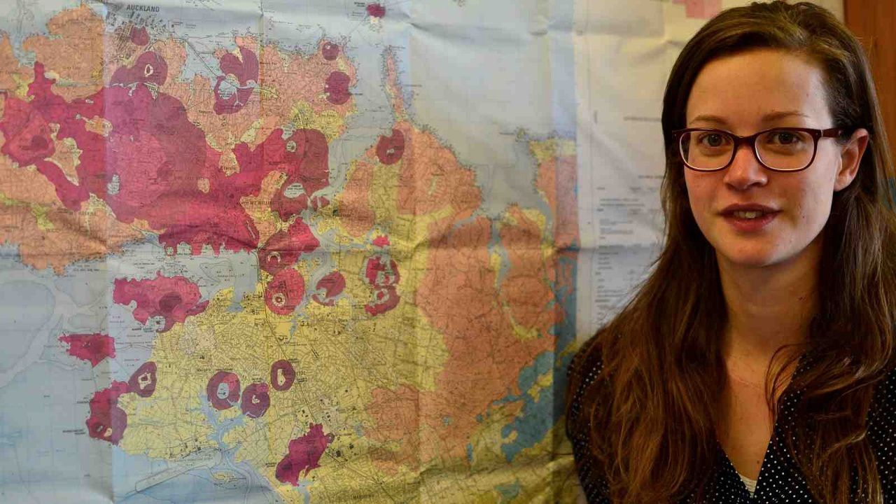 Jenni Hopkins and the map of Auckland volcanic field. - Photo Victoria University of Wellington.