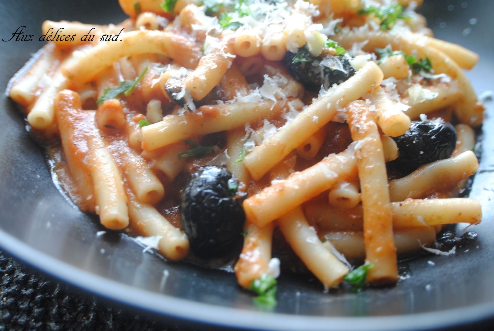 Macaroni à la sauce tomate , pesto , olives noires . Aux délices du sud