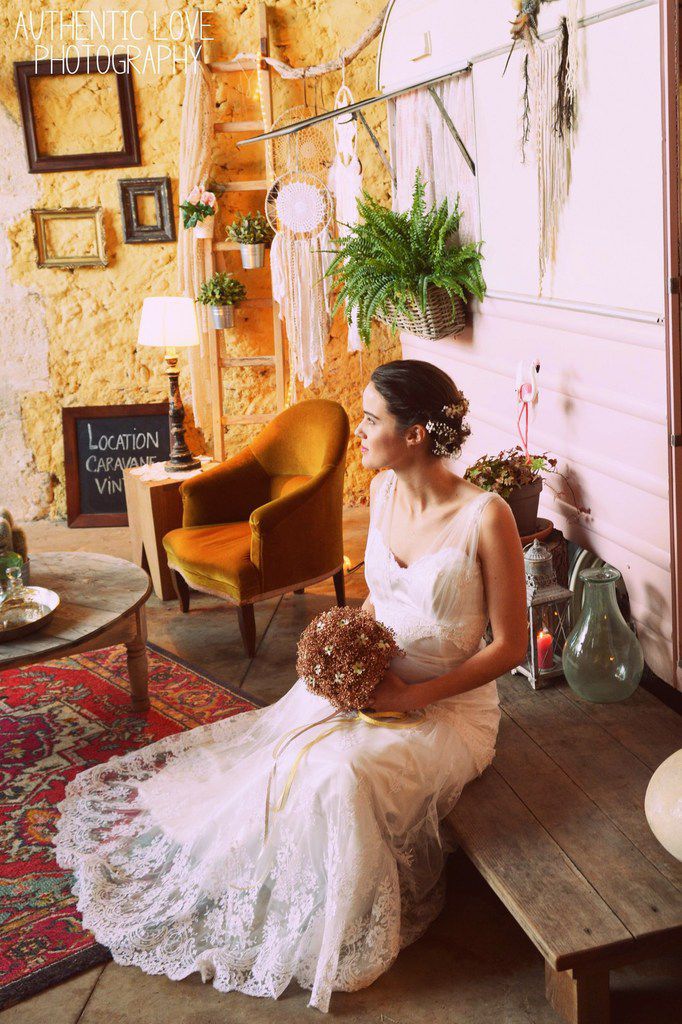 L'adorable mannequin porte une robe de mariée Sarah Dakhli, un bouquet de mariée couture en gypso cuivre par Couturière de la Fleur et la barrette fleurie assortie. Elle pose devant la magnifique caravane vintage d'Une Petite Pièce en Plus