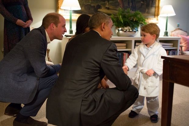 Prince George keeps a close eye on his father, Prince William, while shaking hands with U.S. President Barack Obama at Kensington Palace on Friday. (Pete Souza/The White House via Getty Images)
