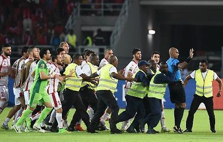 Les membres de la sécurité interviennent pour protéger l'arbitre (d) à la fin du match des quarts de finale de la CAN entre la Guinée Equatoriale et la Tunisie, le 31 janvier 2015 à Bata © AFP - Carl de Souza