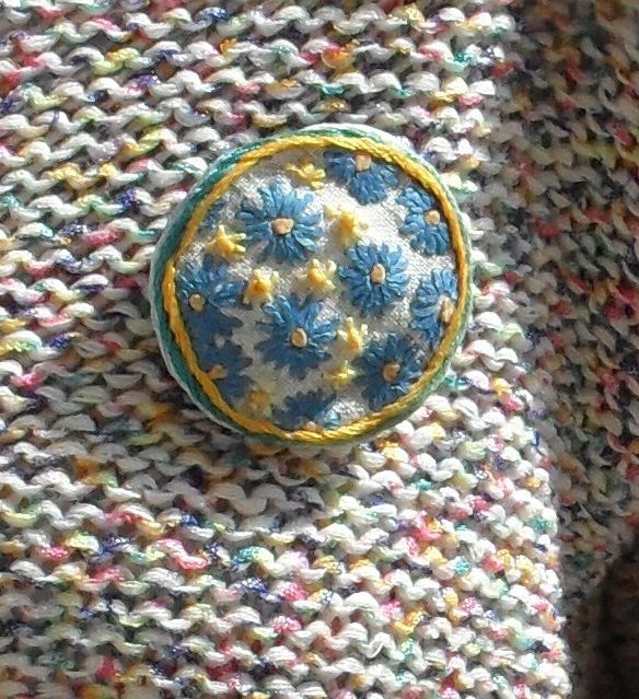 Badge, broche en broderie faite main, fleurs stylisées bleu, jaune sur fond blanc
