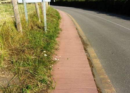 Chemin de bois le long d'une route.
