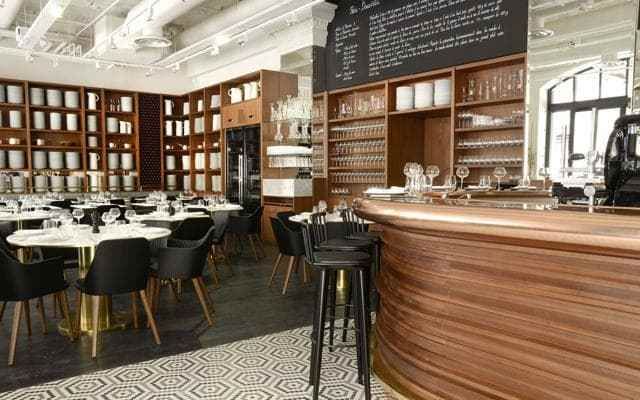 The setting is wonderful: a vast room, its walls stacked with plates and glasses, and two blackboards like arrival and departure panels announcing the stages through the day