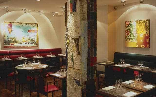 The dining area is a loft-like space with modern art on the walls