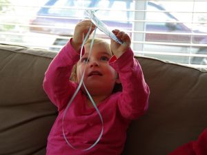 Karla beim Vernaschen ihrer selbstgebastelten Cheerioskette, während Mama das Auto aussaugt.
