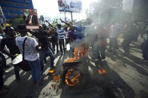 Des manifestants ont bloqué une rue de Port-au-Prince en brûlant des pneus, vendredi (sur la photo), pour demander la démission du président Martelly. PHOTO Hector RETAMAL, AFP
