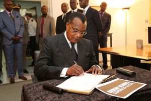 Le président Sassou N'Guesso signant le livre des condoléances