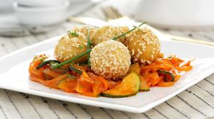 Albóndigas de garbanzo rebozadas en sésamo sobre pisto de verduras