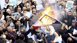 Des manifestants qui protestent contre les caricatures de Mahomet publiées par "Charlie Hebdo" brûlent un drapeau français, à Alger, la capitale algérienne, le 16 janvier 2015.