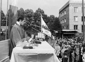 le père Georges prechant sur la place publique