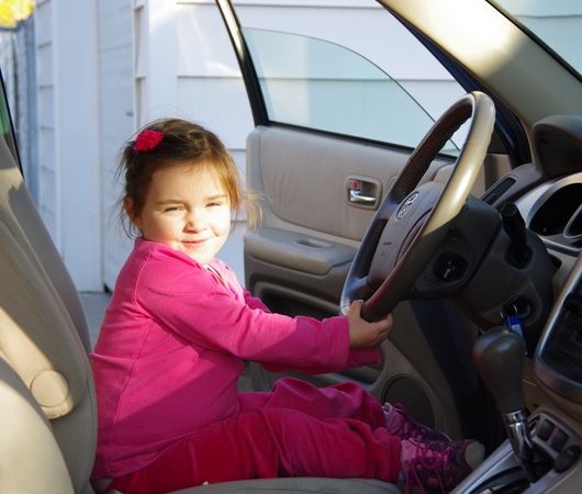 Karla beim Vernaschen ihrer selbstgebastelten Cheerioskette, während Mama das Auto aussaugt.