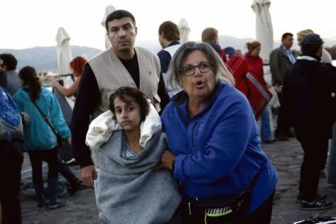 Octobre 2015. Sur l’île de Lesbos, une habitante réconforte une petite fille naufragée. Photo : Giorgos Moutafis/Reuters
