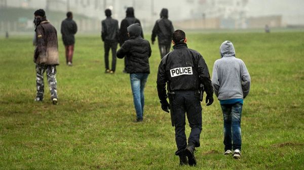 Foto : La polico provas malhelpi migrantojn atingi la kamionojn kiuj direktiĝas al Britio, en oktobro 2014 en Kalezo (PHILIPPE HUGUEN / AFP)