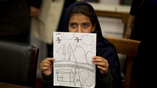 Nabila Rehman tenas sian desegnaĵon, kiu reprezentas la bombadojn de senpilotaj aviadiloj kontraŭ ŝia vilaĝo en Pakistano