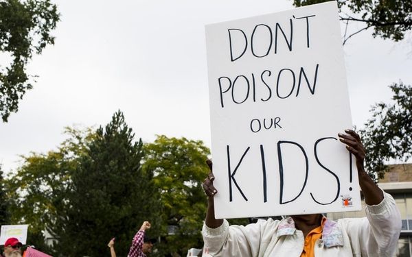 Foto: Loĝantoj protestas kontraŭ la venena akvo ekster Flint City Hall, la 5an de oktobro 2015, en Flinto.Danny Miller / The Flint Journal-MLive.com / AP