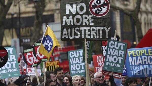 « Haltigu la militon, ne la socian helpon » estis legebla sur unu el la afiŝtabuloj en la manifestacio ĉi-sabate en Londono, kontraŭ la rigorecaj aranĝoj de la registaro. REUTERS/Neil Hall.