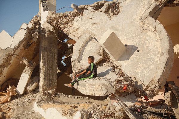 Palestina knabo ludas proksime de sia eks-hejmo, oriente de Gazaa sektoro/ MAJDI FATHI/NurPhoto