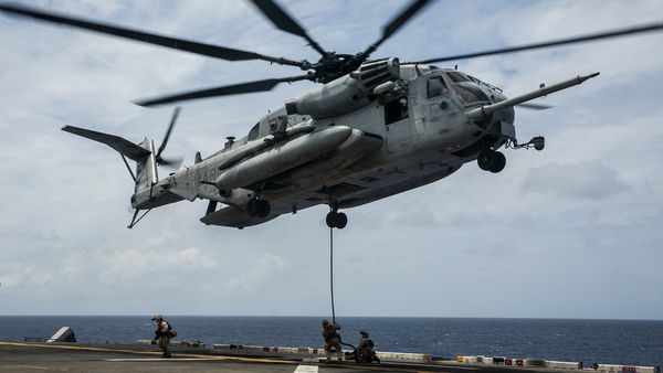 Photo : © USMC - Un CH-53E Super Stallion dépose une cargaison sur un navire.