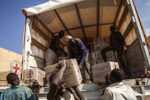 Des volontaires sud-soudanais déchargent un camion de vivres du CICR.