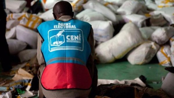 Un agent de la CENI empêtré dans un amas de sacs de bulletins