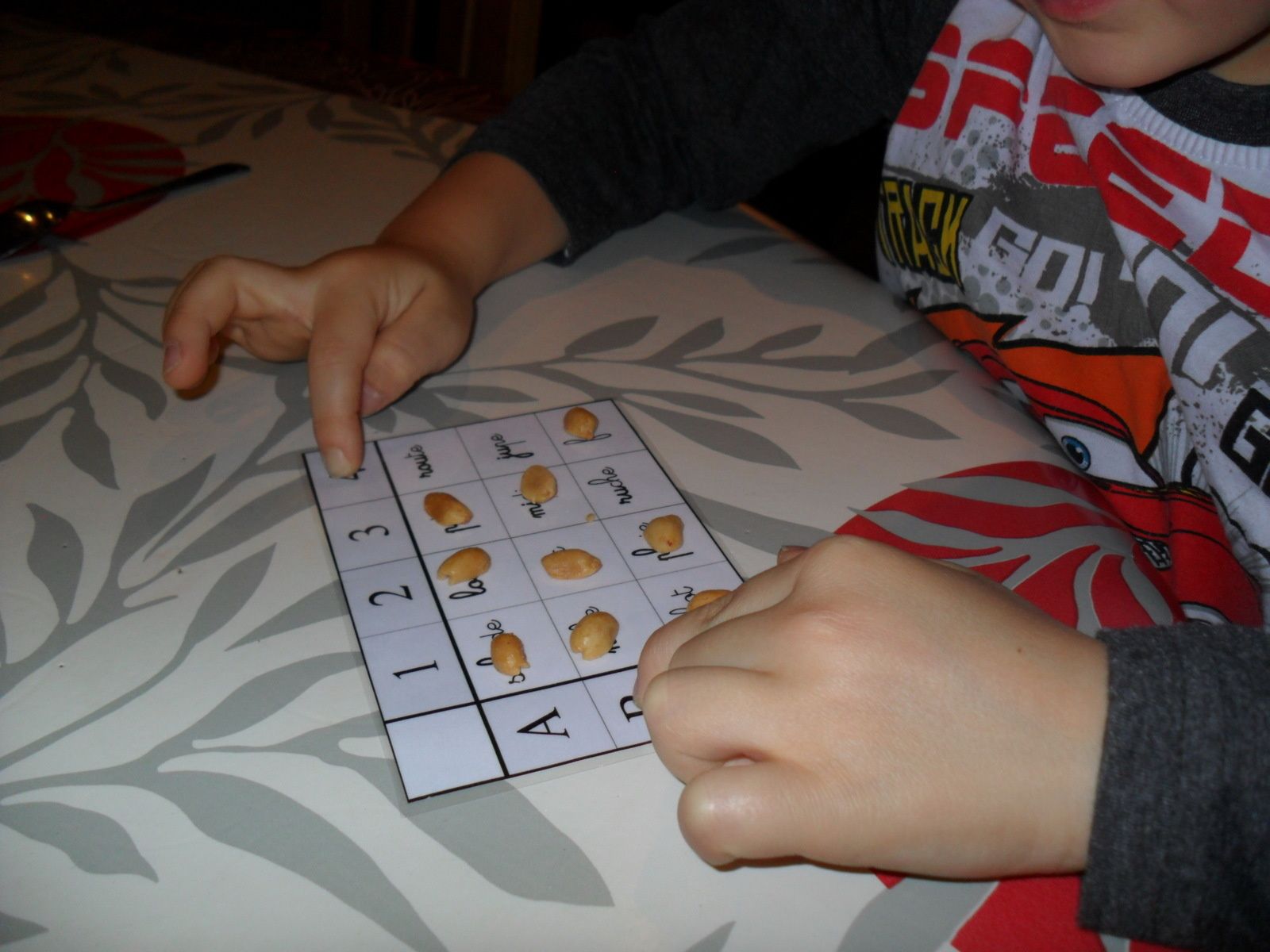 Ce jeu est aussi intéressant pour travailler les tableaux à double entrée. Sur la photo, on voit Jonah faire glisser ses doigts pour trouver la case B4.