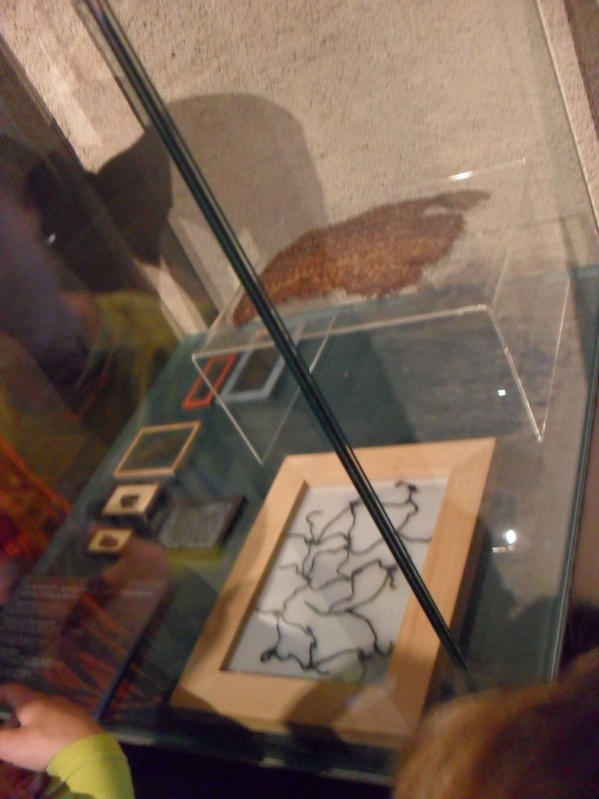 Dans le cadre, un ancien filet de pêche, en hauteur, ce qui reste d'un panier tressé.