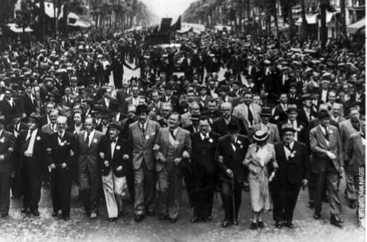 14 juillet 1939, les communistes déﬁlent à Paris. Résonnent dans les cortèges les appels à secourir l’Espagne républicaine et ses réfugiés qui croupissent depuis le début de l’année dans des camps. Face aux nuages qui obscurcissent l’horizon, au PCF on envisage déjà de se préparer à la clandestinité...