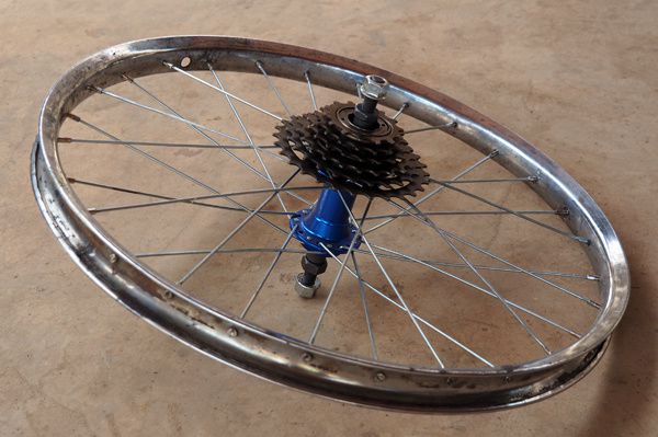 La roue arrière est remplacée par une petite roue (taille vélo enfant) muni de plusieurs pignons.