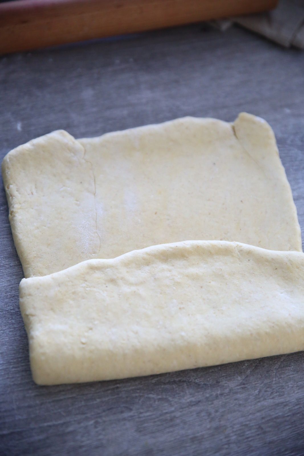 Etaler le pâton de manière à former un rectangle d'environ 6mm d'épaisseur et replier en portefeuille. Filmer soigneusement pour ne pas que la pâte dessèche. Mettre au frais 2h.