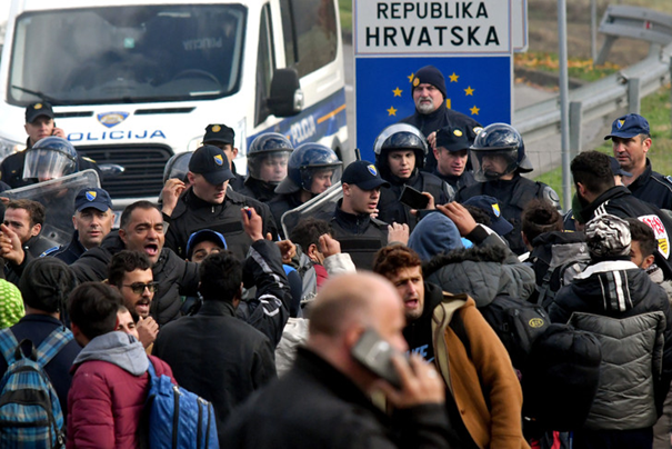 Des migrants face à un blocus de la police, sur la frontière avec la Croatie, à Velika Kladusa, en Bosnie-Herzégovine, le 24 octobre 2018 / AFP/Archives