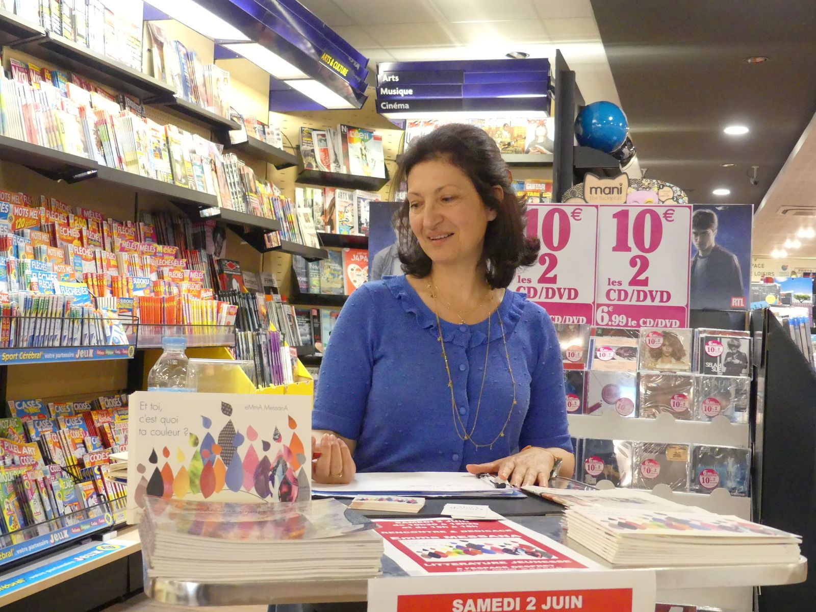 eMmA MessanA couvant du regard son dernier album jeunesse "Et toi, c'est quoi ta couleur ?"