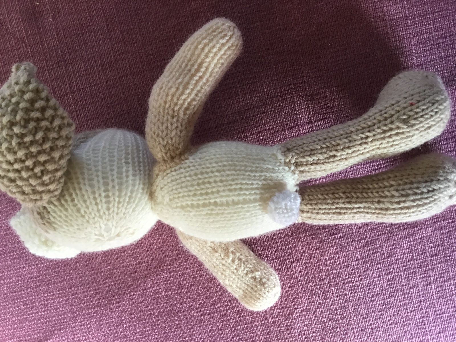 adorable petit lapin en tricot de dos nous montre sa petite queue