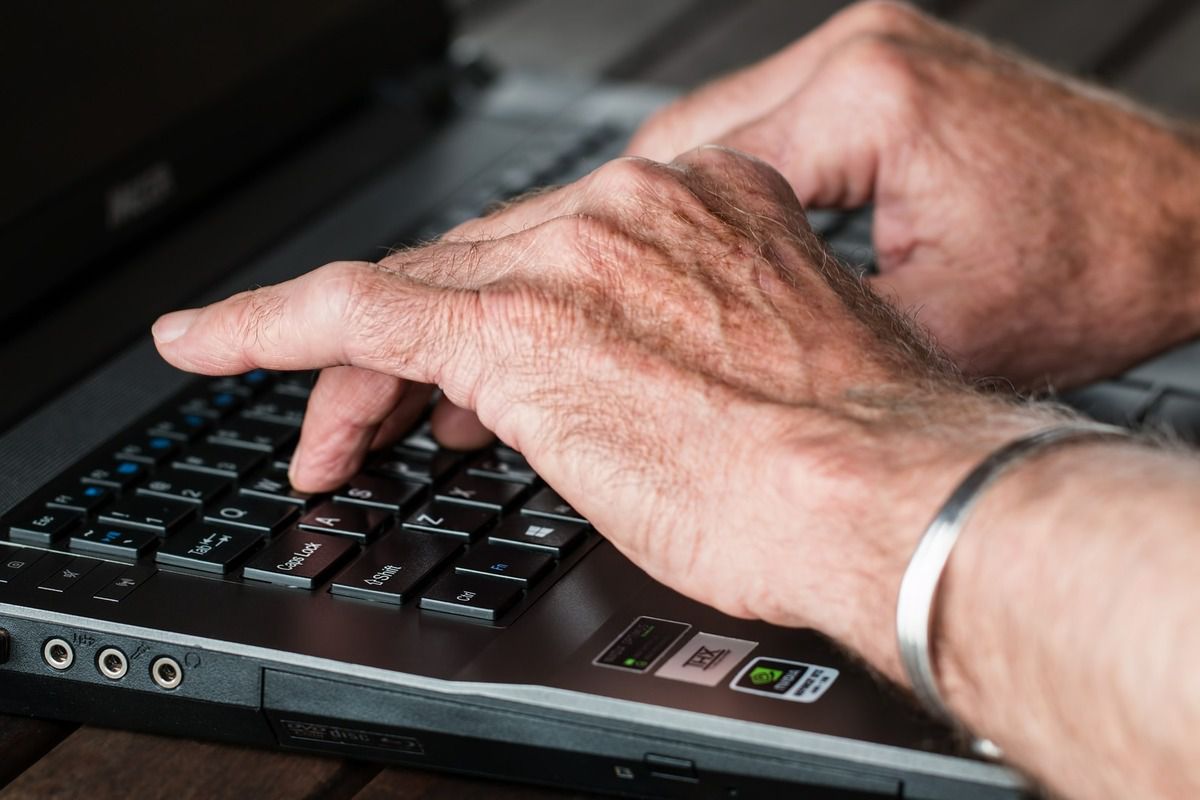 main d'un homme qui pianote sur le clavier d'un ordinateur  portable