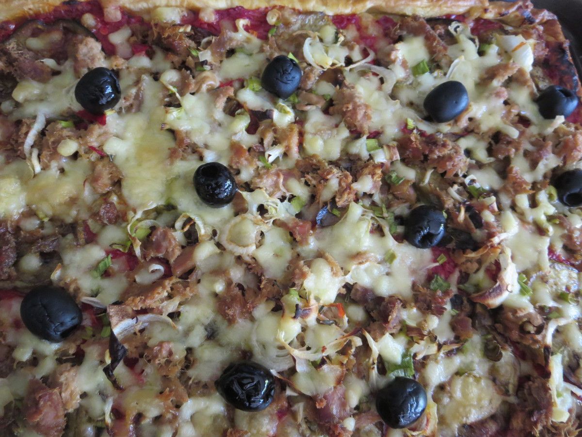Maintenant, on peut préférer une pizza maison. Sur une pâte à pain, tomates, aubergines, oignons frais, thon, olives, mozzarella râpée, basilic et huile d'olive 