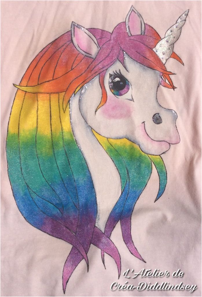 Le voici d'un peu plus près j'ai donc utiliser la peinture Darwi tex blanche ainsi que les couleurs nacrées et le argent. Après séchage j'ai fixé la peinture au fert 5min , puis j'ai ajouté des paillettes irisé mélanger à la peinture tulip 3D clear et des strass en cristal sur la corne et des paillettes argent holographique mélangé toujours à la peinture tulip 3D sur certains détails.