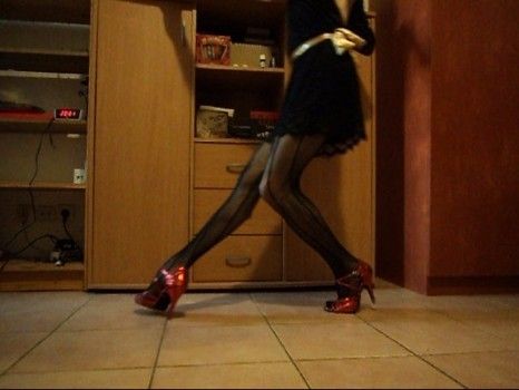 Robe noire dentelle mi-cuisse dos nu jusqu'à la naissance des fesses, collants résille, homme qui danse dans son appart
