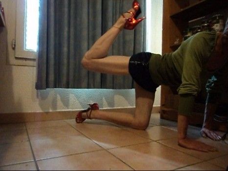 Gambettes musclées, fitness à quatre pattes, stretching d'un mec vêtu comme une fille, en levrette et jambe en l'air