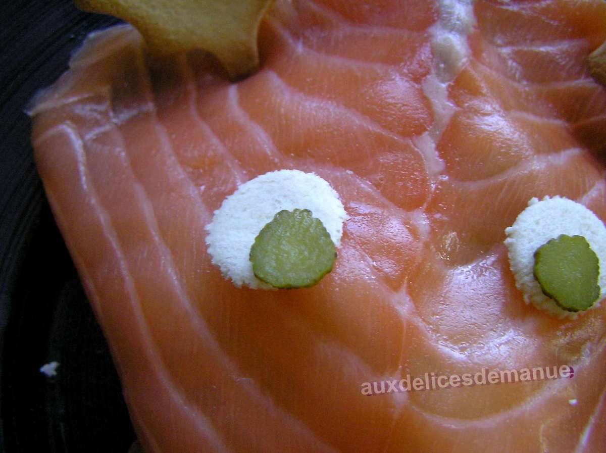 Coupez un peu la base de la tomate pour qu'elle soit bien stable et déposez-la sur la tranche de saumon pour que ça fasse le nez du renne.