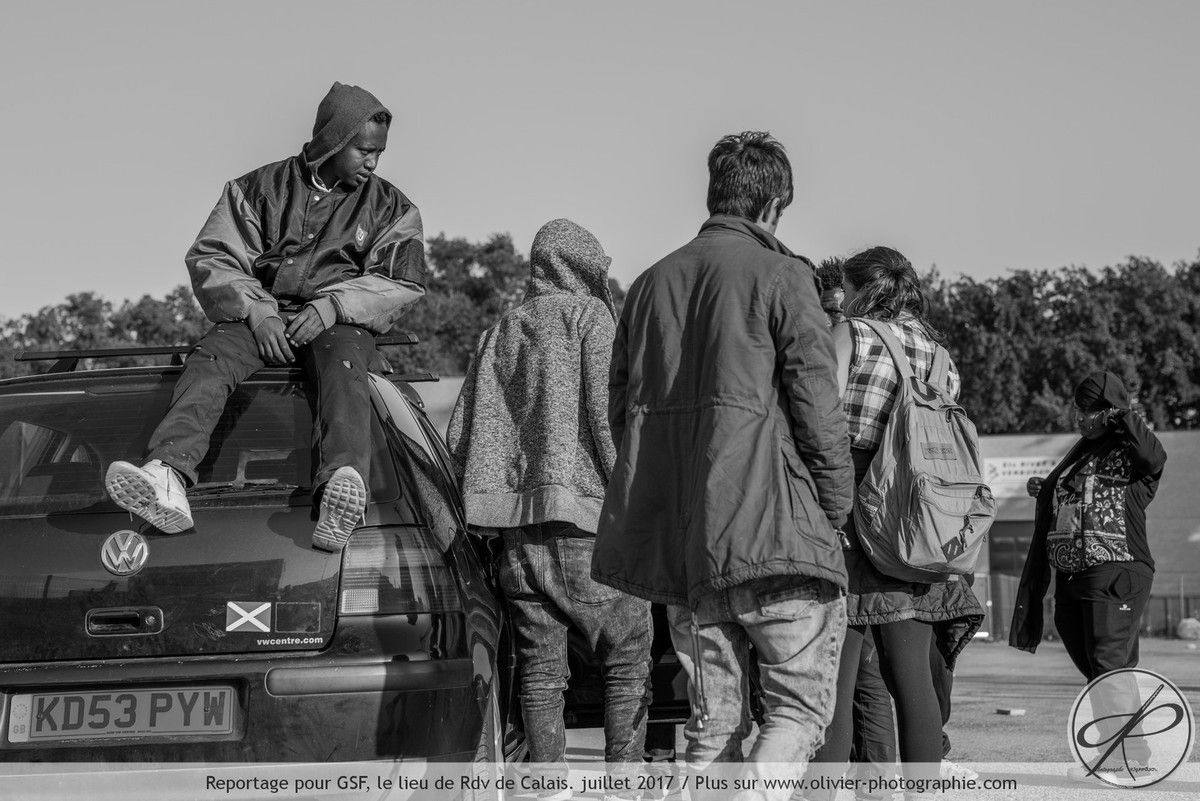 un groupe en train d'écouter de la musique sur la voiture d'une jeune bénévole