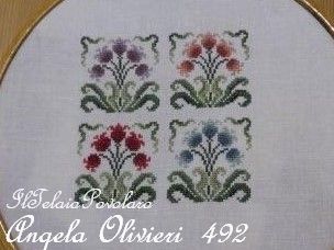 Quattro fiori e quattro colori invece per la cornice-telaietto di Angela Olivieri