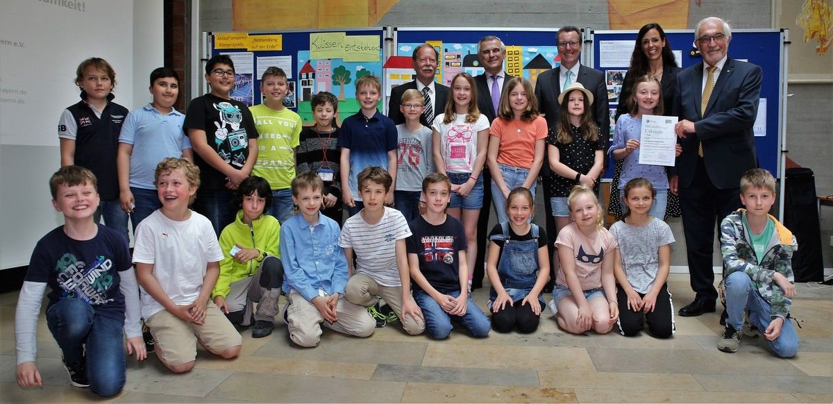 So sehen Sieger aus: Unter 47 Schulen in Bayern errangen die 25 Schüler der Klasse 4 c der Grundschule Veitshöchheim mit ihrer Klasslehrerin Julia Heres (hinten 2. v.r.) den von der Landesverkehrswacht Bayern und der TÜV SÜD Stiftung ausgelobten 1. Förder-Preis "Innovative Verkehrserziehung in der Schule" 2017 und damit verbunden ein Preisgeld von 2.000 Euro. Auf dem Foto übergibt Unterfrankens Regierungspräsident Dr. Paul Beinhofer (re.) die entsprechende Urkunde, assistiert hinten v.l. Dr. Dieter Aufderhaar, Horst Schneider und Bürgermeister Jürgen Götz, der den 1. Preisträgern einen Eisgutschein spendierte..