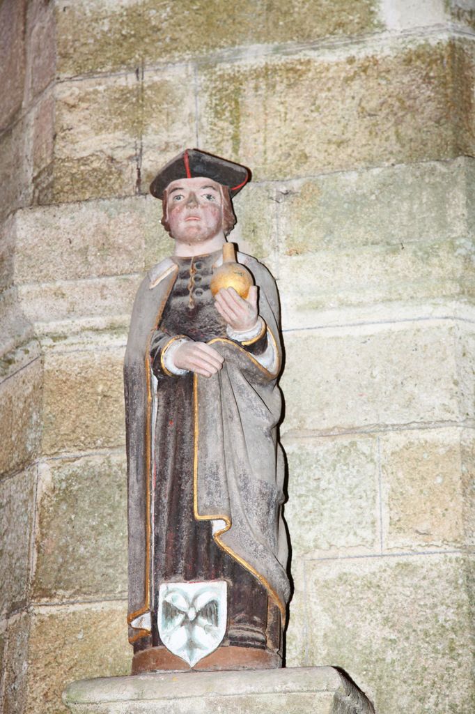 Saint Côme tenant l'urinal, statue en bois polychrome, XVIIe,  de l'église de Ploudiry. Photographie lavieb-aile.